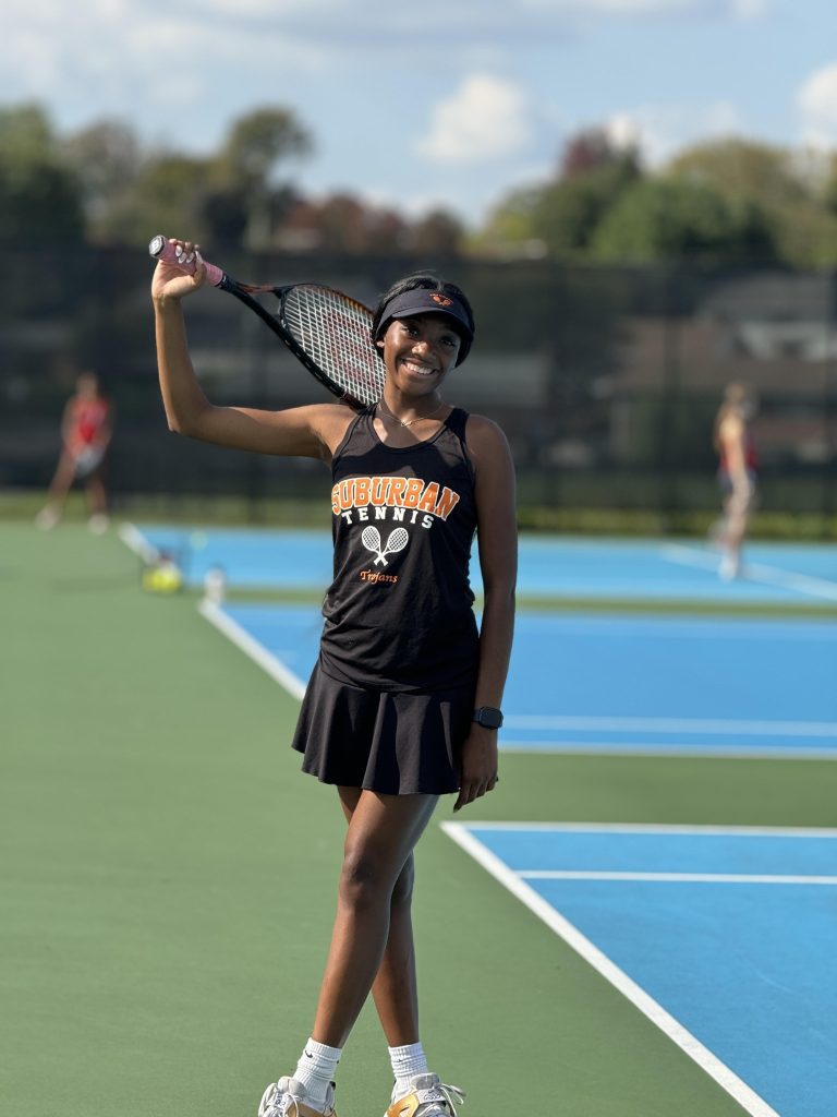 Senior Cine' Stevenson in her tennis uniform holding a tennis racquet